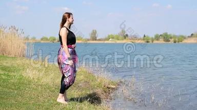 小女孩站在岸边，看着大自然，深呼吸